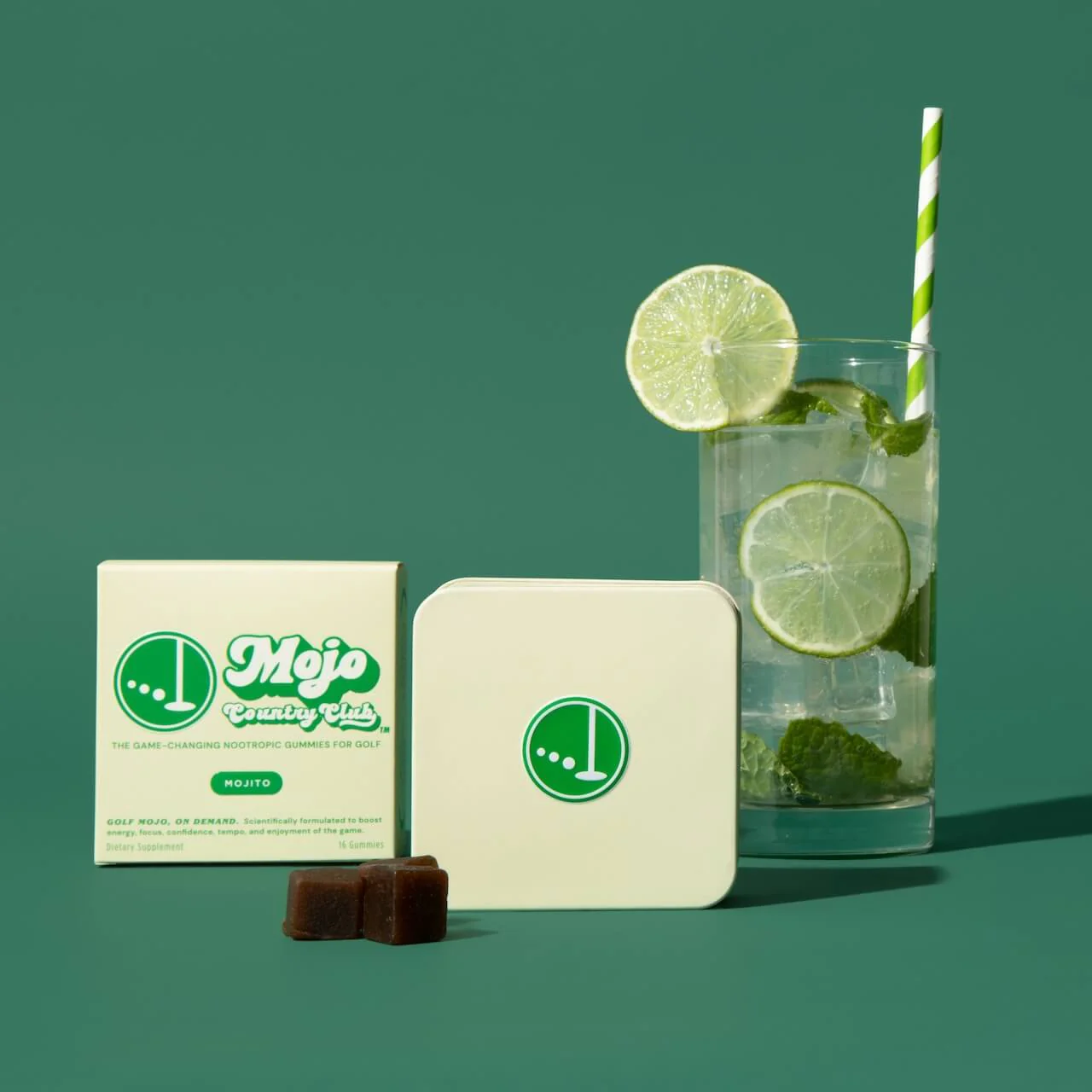 A glass drink with gummy products in front of a green background